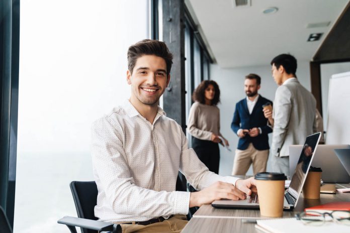 Attractive,Young,Confident,Businessman,Sitting,At,The,Office,Table,With