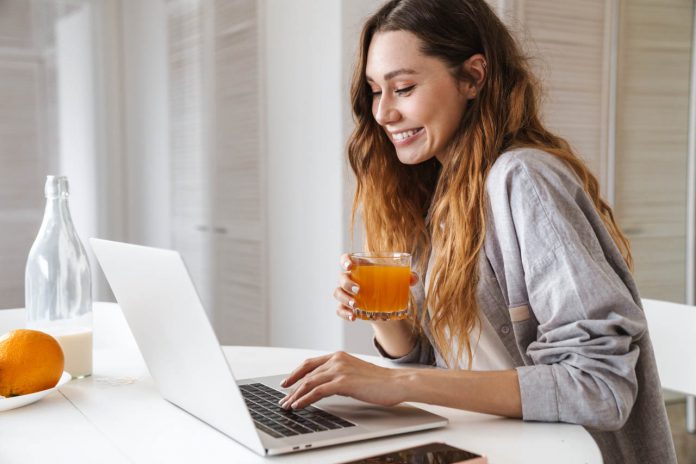 Pretty,Cheerful,Young,Woman,Having,Breakfast,While,Sitting,At,The