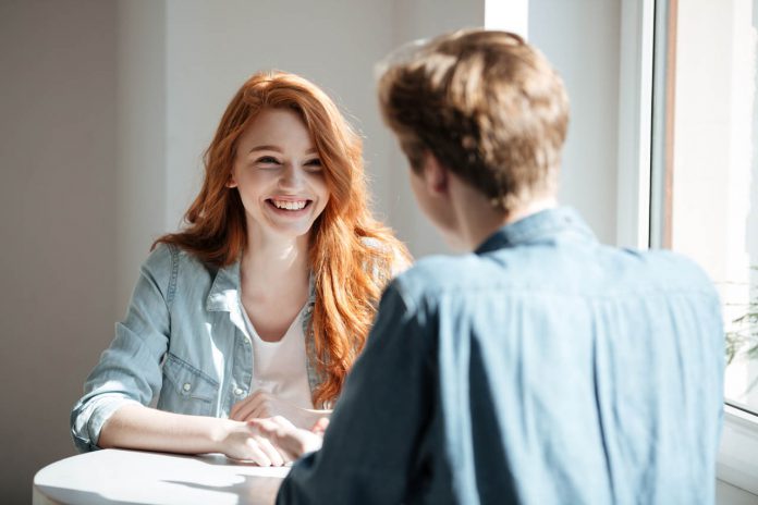 Young,Woman,Student,Laughing,While,Talking,In,Cafe