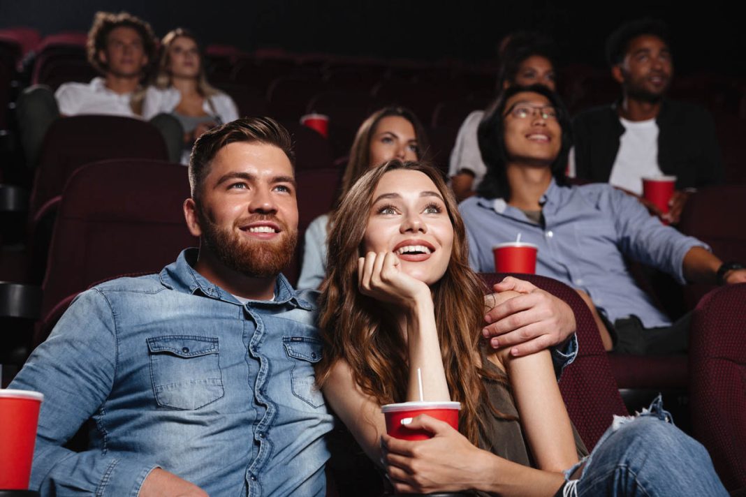 Happy,Young,Couple,Sitting,At,The,Cinema,And,Enjoys,Watching