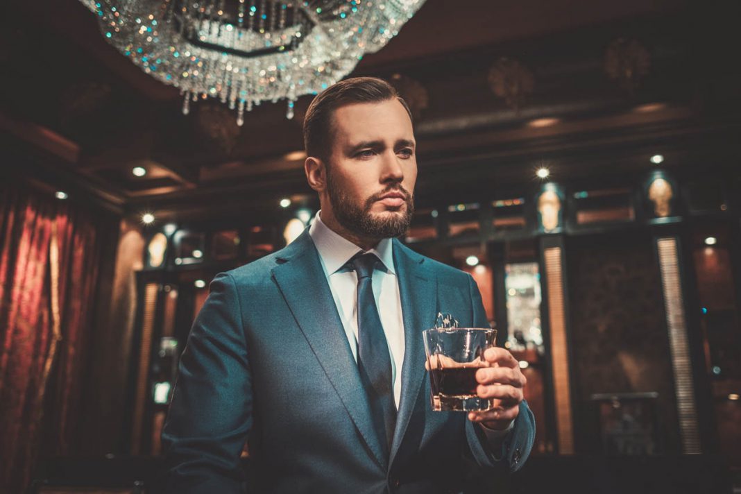 Confident,Well-dressed,Man,With,Glass,Of,Whisky,In,Luxury,Apartment