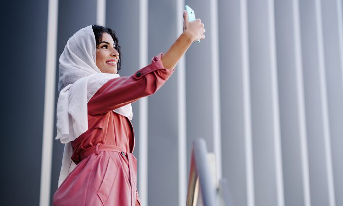 Muslim Woman with hijab taking selfie with smartphone