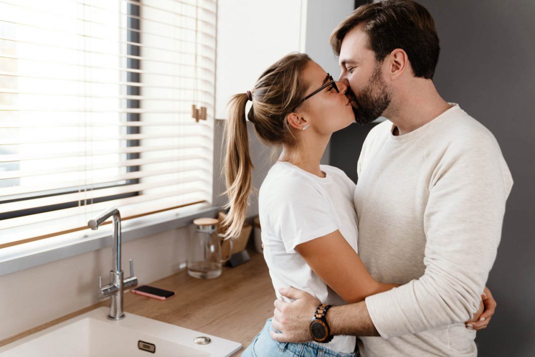 Beautiful,Happy,Caucasian,Couple,Kissing,And,Hugging,At,Home,Kitchen